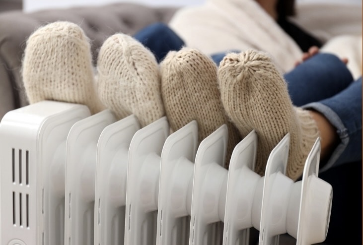 Voeten met wollen sokken tegen een verwarming